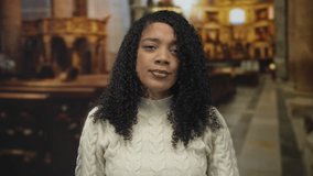 Woman with curly hair and hand on forehead in stone church building; reflection contemplation faith solemnity. - Powered by Shutterstock - Get 15% off with code: PIKWIZARD15