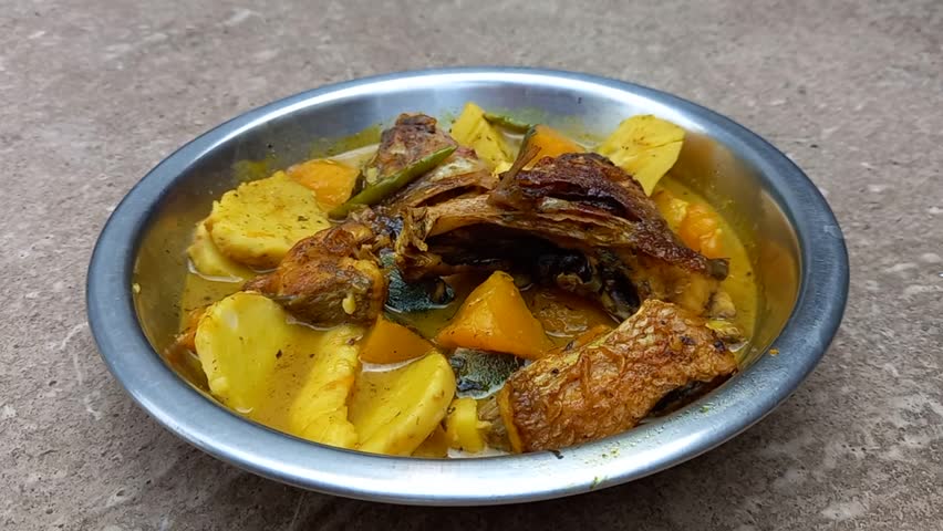 A bowl of fish sour curry, a delicious and flavorful dish.It is presented indoors, emphasizing the comfort of home-cooked meals.