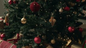 Piles of gift boxes in various sizes wrapped in decorative paper and colorful ribbons lying under illuminated Christmas tree in living room during daytime - Powered by Shutterstock - Get 15% off with code: PIKWIZARD15