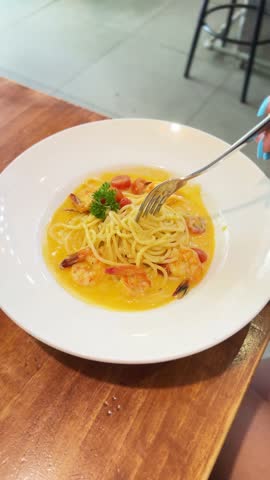 Fork twirling spaghetti seafood shrimp pasta in a creamy sauce