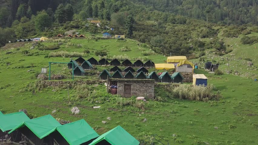 Aerial Drone View of a Campsite on a Mountain Top in Kheerganga near Kasol, Himachal Pradesh, India — Featuring Tents, Mountain Slopes, and the Scenic Himalayan Landscape for Adventure Travel