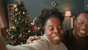 Cheerful African American family of two adults and girl child video calling relatives to give Christmas greetings while writing on cards and decorating presents at table then kissing goodbye - Powered by Shutterstock - Get 15% off with code: PIKWIZARD15
