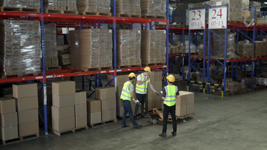 Blue collar workers are working at warehouse. Logistics, transportation.