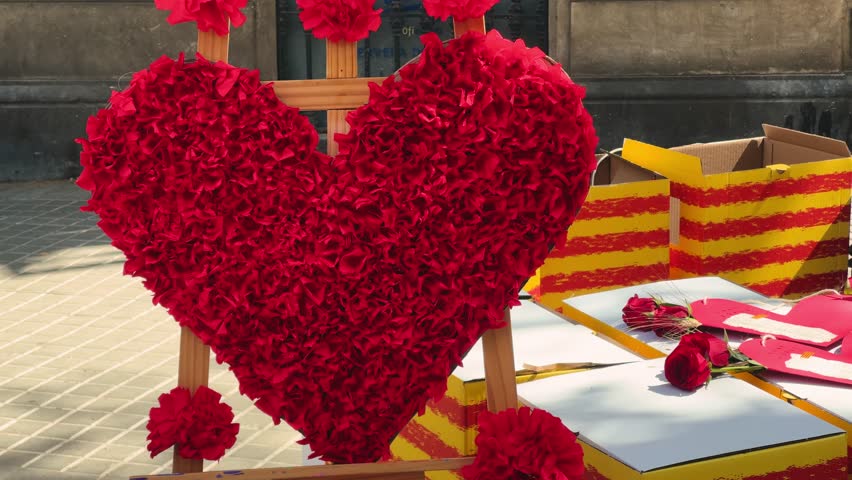 Sant Jordi, holiday of Catalonia patron. Men give a rose to women, women give them a book in exchange. Street stall with roses and books. High quality 4k footage