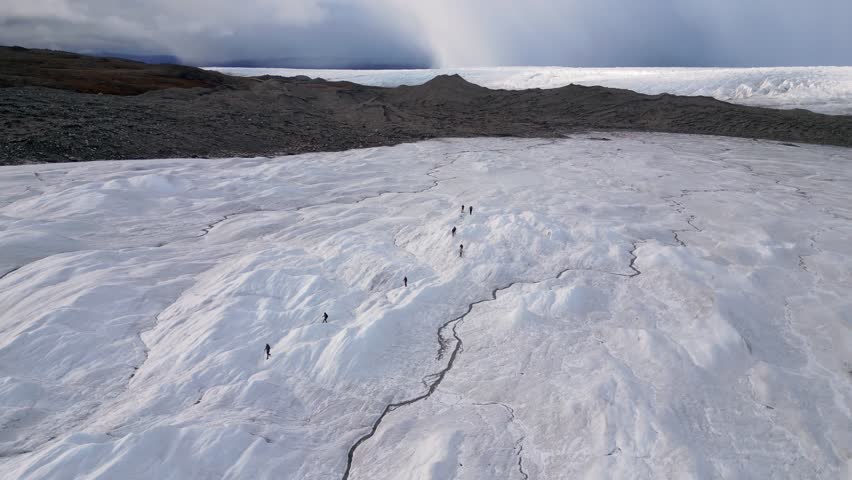 Ecotourism group hikes on vast Russell Glacier in Greenland arctic