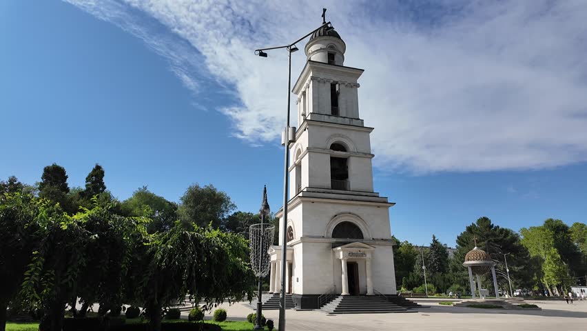 This video shows Cathedral Park and the Nativity Cathedral in the center of Chisinau, Moldova. The footage captures the white Orthodox cathedral surrounded by trees and walking paths in the park.