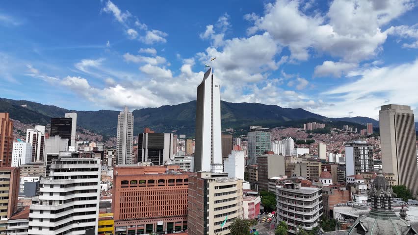 A stunning daytime cityscape of downtown Medellín, Colombia, featuring the iconic Coltejer Building