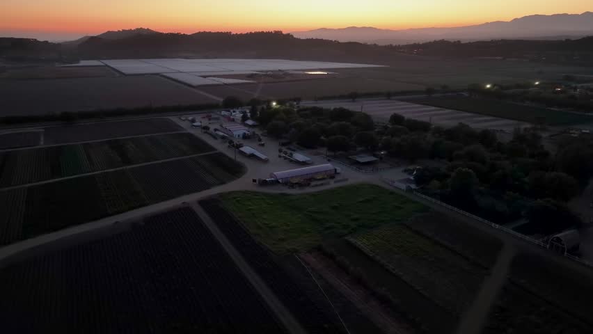 Fields Of Crops At A Commercial Farm Business At Sunset In America. Parallax Aerial Shot.