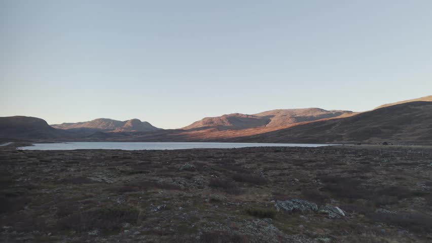 Sunset over a lake and mountains in Hemsedal, Norway. Drone footage