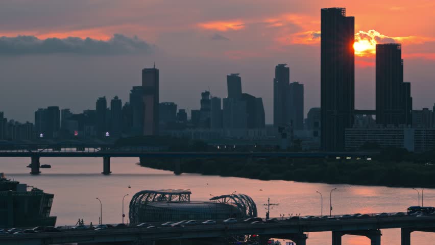 Aerial cityscape of Banpo Bridge with vehicle silhouettes set against dramatic sunset behind Raemian Caelitus Tower 101 and the modern Seoul skyline
