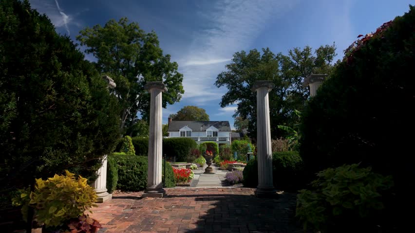 Discover the serene gardens at the Museum of the Shenandoah in Winchester, VA. Enjoy the vibrant flowers and stunning architecture on a cloudy day.