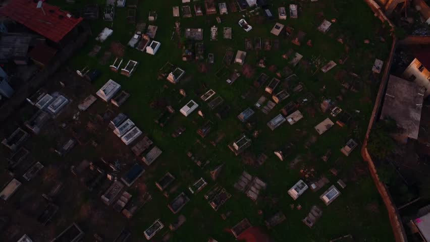 Closeup of quiet cemetery under a dim daylight in countryside. Drone fly over the graveyard with tombstones in city of Ibadan, Nigeria, Africa. Aerial footage capture serene and memorial rows of grave