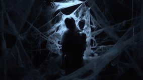 Silhouette of Dramatic zombie man trapped in spiderwebs on dark night background. Halloween fantasy horror scene. - Powered by Shutterstock - Get 15% off with code: PIKWIZARD15