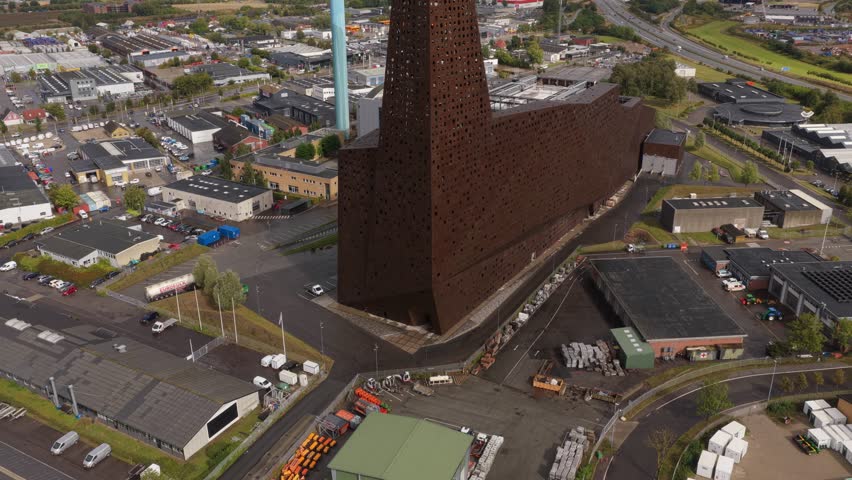Industrial plume rises above the Roskilde Energy Tower, capturing the scale and precision of Denmark advanced waste-to-energy operations and district heating network.