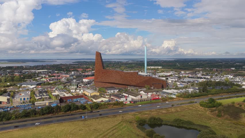A white plume drifts above Roskilde’s Energy Tower, Denmark modern waste-to-energy facility, showcasing sustainable power generation and striking industrial architecture.
