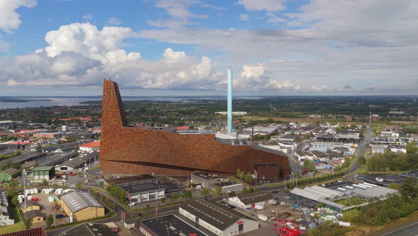 Energitarnet in Roskilde emits a gentle exhaust plume—Denmark landmark waste-to-energy plant marrying bold architecture with efficient urban power and heating.