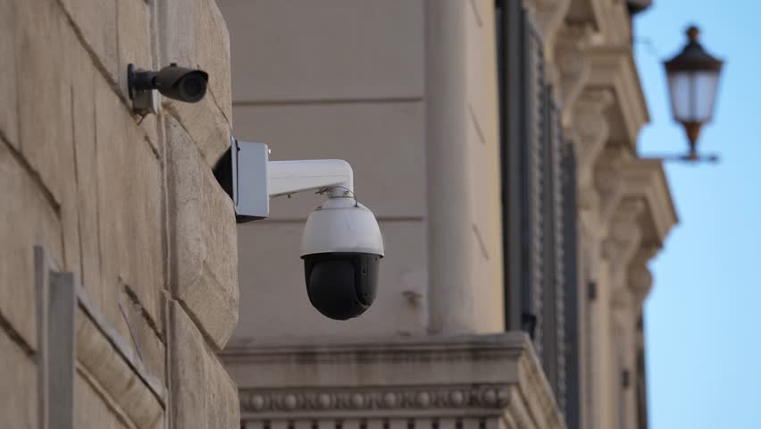 Surveillance cameras mounted on street corner monitoring traffic