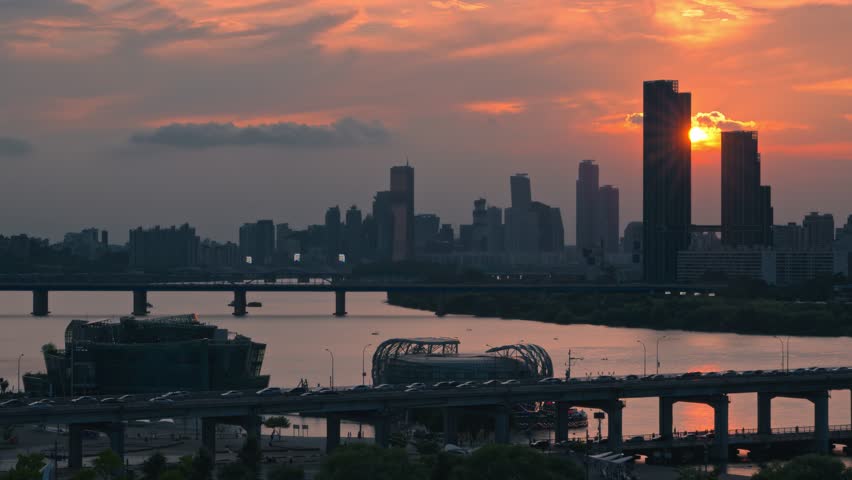 Aerial real time view of dramatic sunset next to Raemian Caelitus Tower 101 skyscraper above Banpo Bridge with Han River and Some Sevit islands in silhouette