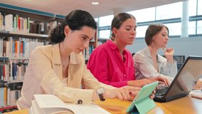 A group of dedicated students engaging in collaborative study using a laptop and tablet for their academic projects in a library, showcasing teamwork and concentration on their work. - Powered by Shutterstock - Get 15% off with code: PIKWIZARD15