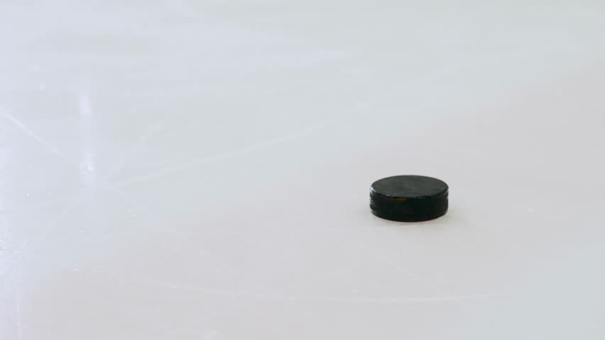 A hockey player deflects the puck on the ice, close-up. 