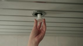Electrician changing round led lightbulb in recessed ceiling fixture, performing routine indoor home improvement, maintenance, repair, providing proper lighting, close-up. Shooting in slow motion. - Powered by Shutterstock - Get 15% off with code: PIKWIZARD15