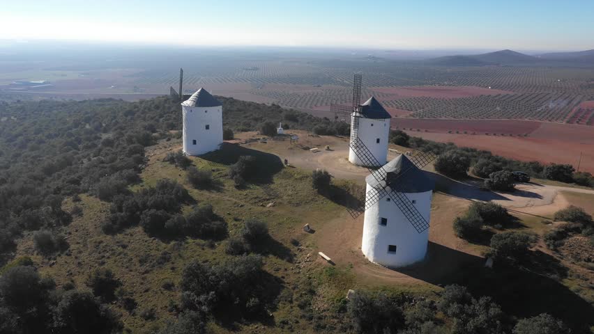 Aerial view of windmills in the countryside in Spain - White windmills in Castilla La Mancha region on a sunny day - Travel destinations and industrial architecture in southern Europe