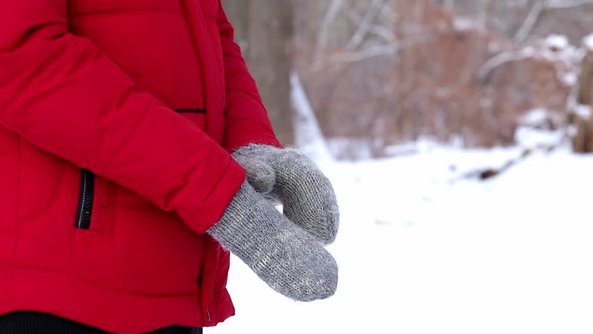 A man froze on a walk in a winter forest and is trying to warm his hands.Winter frosty atmosphere.