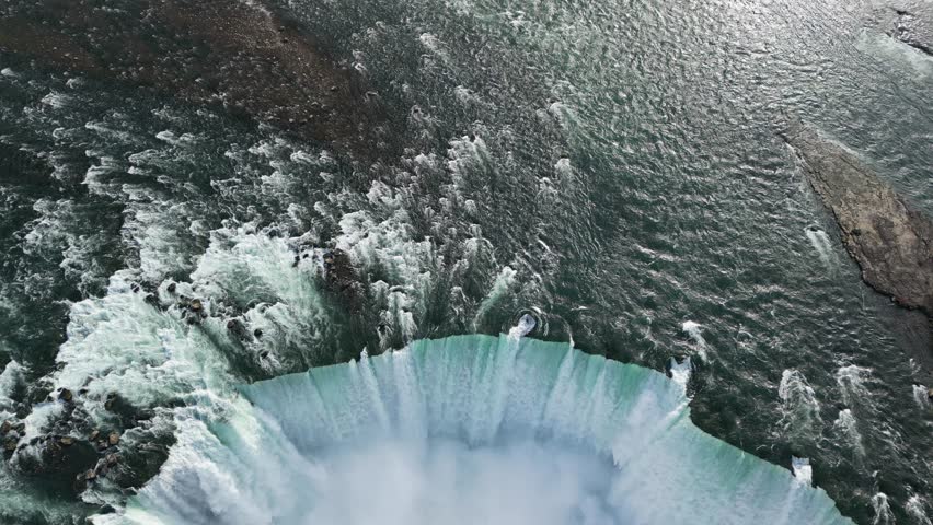 Sweeping drone movement across the edge of Niagara Falls, showcasing the incredible scale and roaring water power