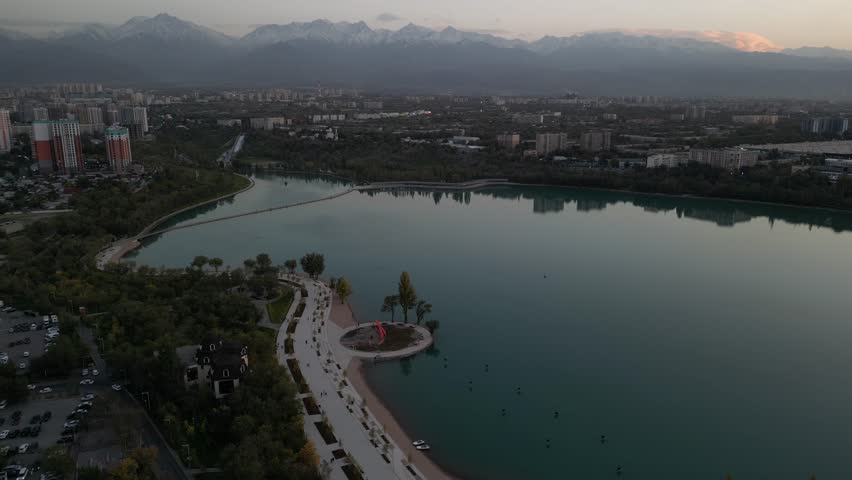 A city lake at sunset with the mountains in the background. Almaty, Kazakhstan