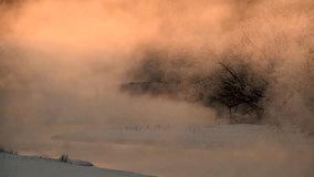 Golden mist rises over a serene winter river, reflecting the sunrise, while frost covered trees line the snowy bank and distant snow geese gather in the fog - Powered by Shutterstock - Get 15% off with code: PIKWIZARD15