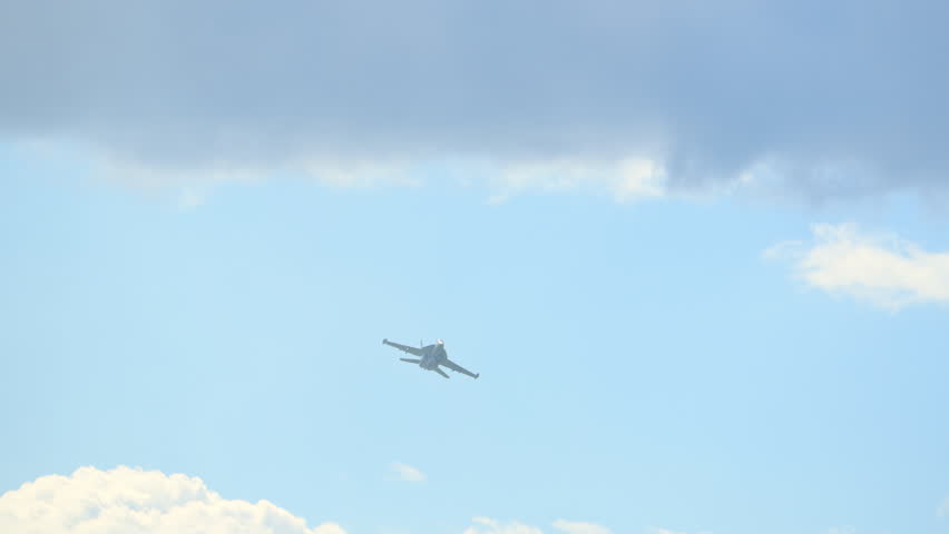 Slow motion view of F-18 fighter jets at full power flying beneath the clouds, showcasing military strength, speed, and precision.