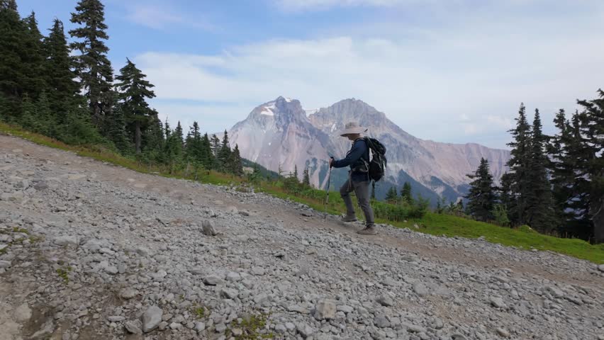 Adventurous Hiker Descending Rocky Mountain Trail in Whistler, British Columbia, Canada