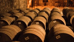 Warmly lit warehouse interior with rows of wooden barrels, slow lateral camera movement, rustic atmosphere - Powered by Shutterstock - Get 15% off with code: PIKWIZARD15