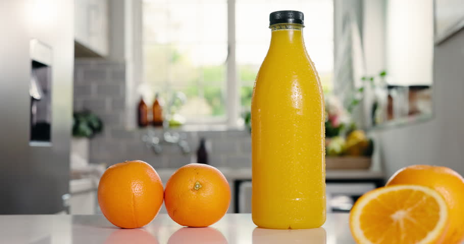 Nutrition, juice or bottle in kitchen with orange, antioxidant or vitamin benefit in morning drink. Organic, hydration or fruit in home with detox diet, gut health or digestion in breakfast beverage.