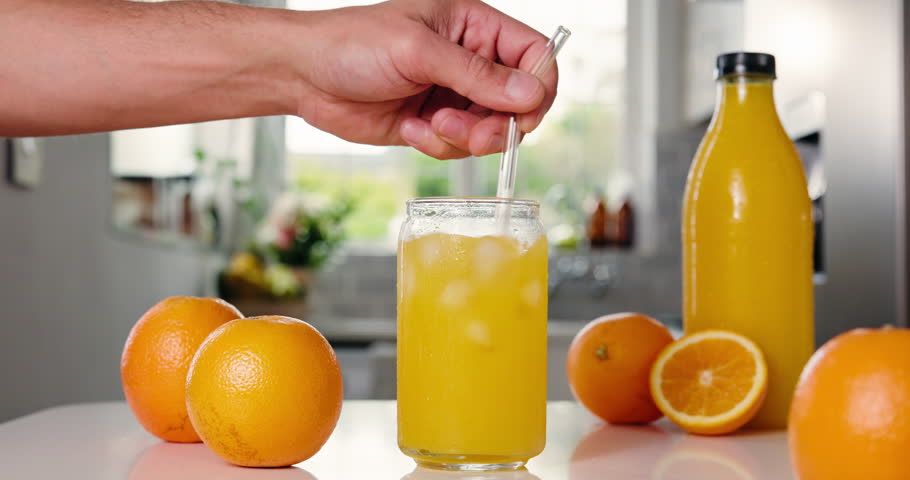 Nutrition, orange juice or person in kitchen with straw, antioxidant or vitamin benefit in morning drink. Organic, fruit and hand in home with stirring, gut health or digestion in breakfast beverage.