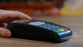 Close up man At Counter Buy electronic payment supermarket by credit card. Male hand pay for purchases in stores Contactless NFC pos Terminal card reader at cashless wallet. swipe. shop. Electronic - Powered by Shutterstock - Get 15% off with code: PIKWIZARD15