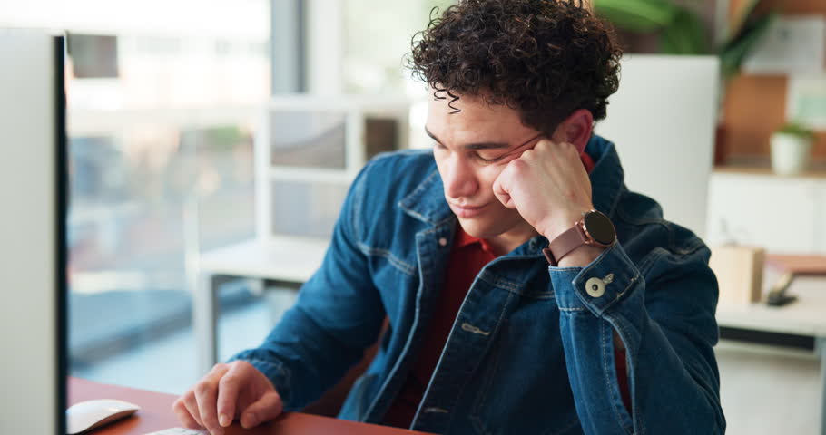 Tired, man and bored with computer in office for burnout, sleepy and low energy for submission. Internship, lazy journalist and tech with fatigue at desk from insomnia, tedious article and overworked