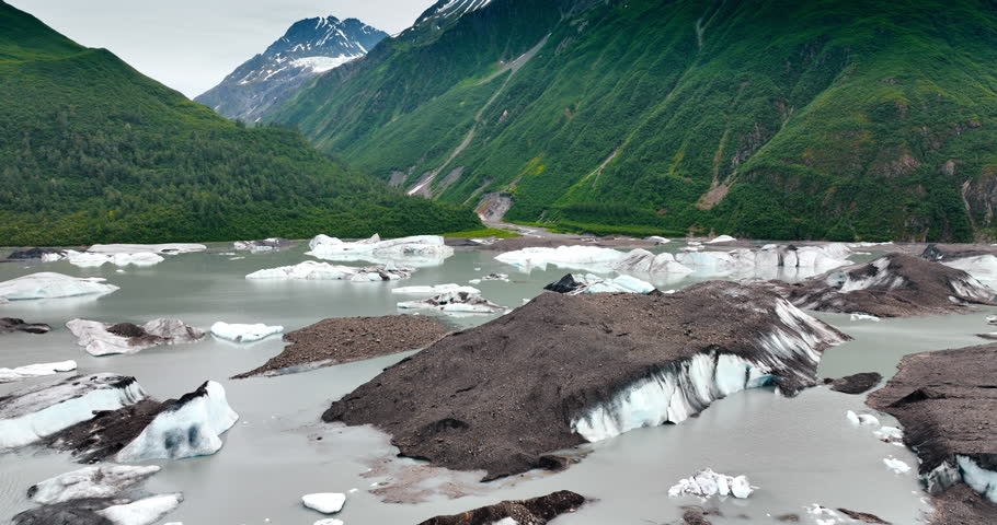 Waterscape in the mountains with boulders of ice sticking out of. Wild nature of Alaska, USA.