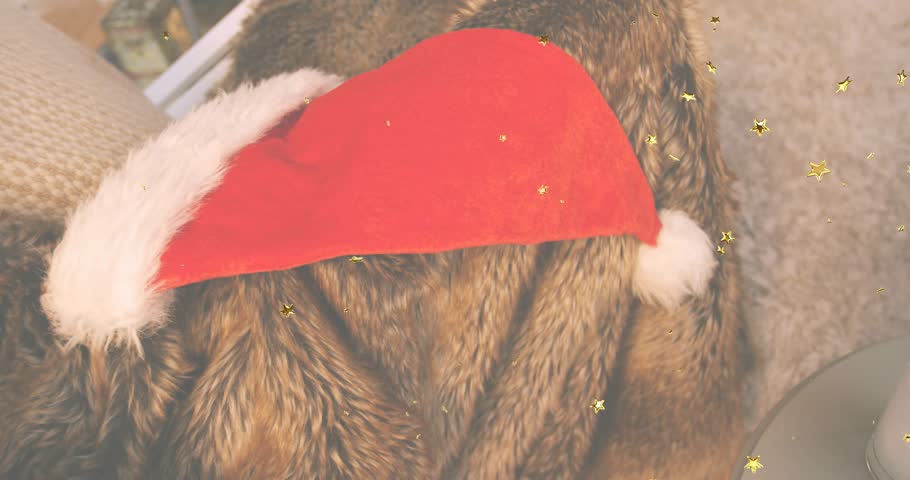 Confetti drifting over red Santa hat on throw, camera panning right revealing milk glass, cookies. Coziness, festive, celebration, warmth, texture, holiday, comfort
