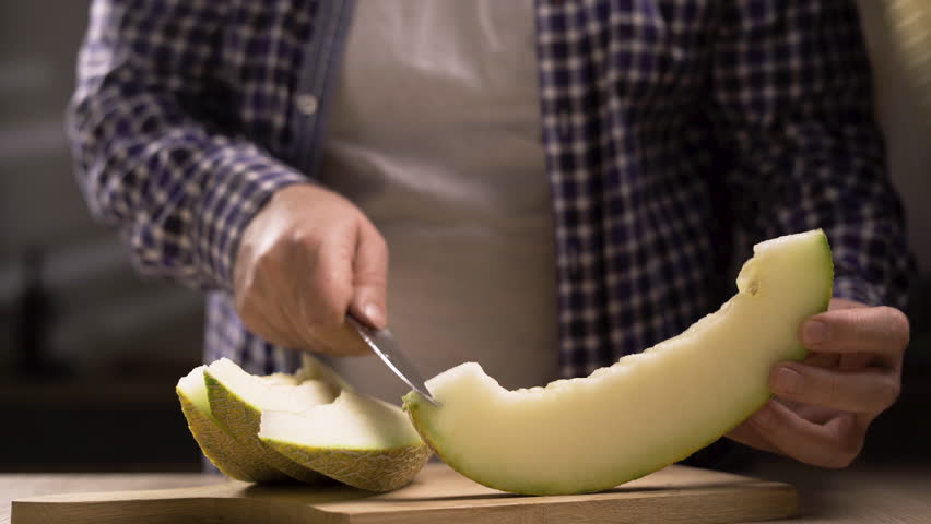Man cleans cantaloupe melon fruit sliced golden melon Cut into pieces