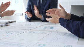 Businesspeople team clapping hands in meeting celebrating success with financial charts, data analysis, sales growth reports, and teamwork achievement in modern office. Business handshake - Powered by Shutterstock - Get 15% off with code: PIKWIZARD15