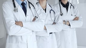 Medical team standing with arms crossed, focusing on healthcare professionals in white lab coats, representing medicine, expertise, and unity in a clinic setting - Powered by Shutterstock - Get 15% off with code: PIKWIZARD15