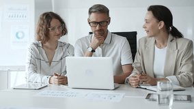 Business team collaborating on a project, analyzing data on a laptop during a productive office meeting, demonstrating teamwork and problem solving skills - Powered by Shutterstock - Get 15% off with code: PIKWIZARD15