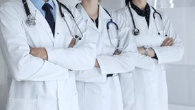 Medical team standing with arms crossed, focusing on healthcare professionals in white lab coats, representing medicine, expertise, and unity in a clinic setting - Powered by Shutterstock - Get 15% off with code: PIKWIZARD15