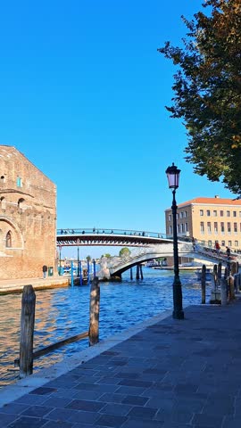 Sunny day view of Venice canal with boats and colorful old buildings