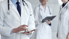 Healthcare professional using a digital tablet for patient data management, doctors collaborating on medical records, modern clinic team focusing on health technology - Powered by Shutterstock - Get 15% off with code: PIKWIZARD15