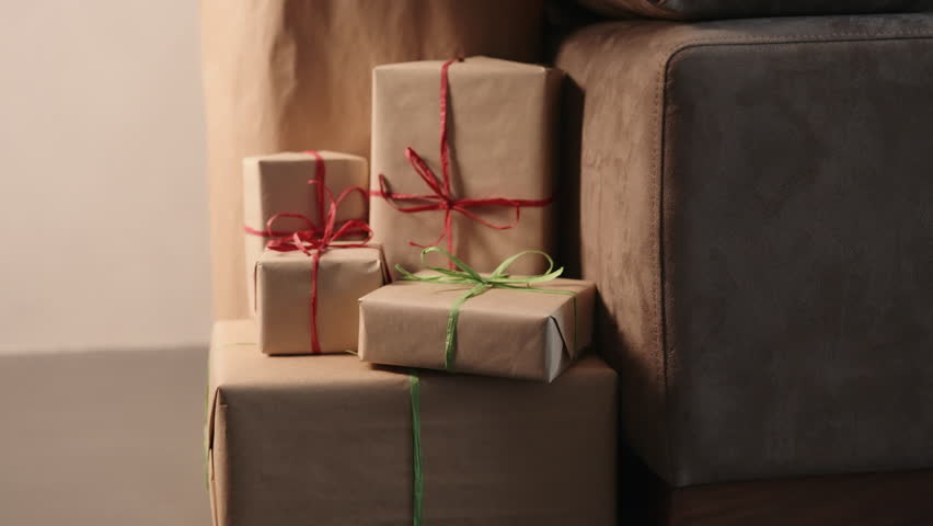 Slide shot of christmas gifts under spruce indoor with warm light
