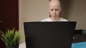 Female student with alopecia studying online on computer, distance learning, focused woman using laptop for education at home - Powered by Shutterstock - Get 15% off with code: PIKWIZARD15
