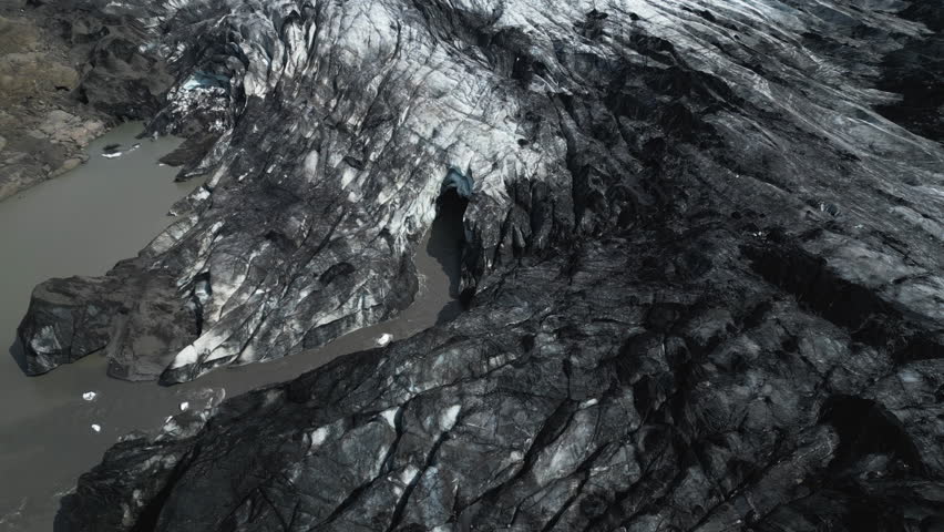 Above View Of Black Ash Jagged Ridges At Sólheimajökull Glacier In Southern Iceland. Aerial Drone Shot