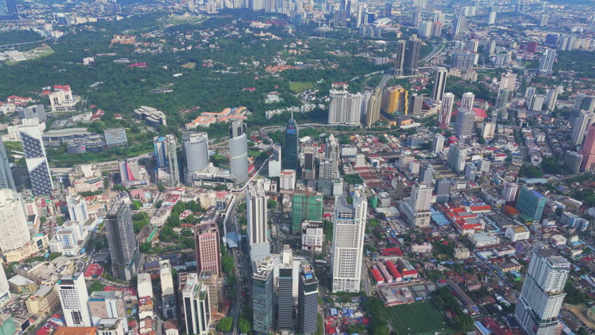 Aerial view of the central districts of Kuala Lumpur with towers, parks, and rail lines under crisp daylight. Malaysia capital city, vibrant skyline and tourism destination with clear visibility